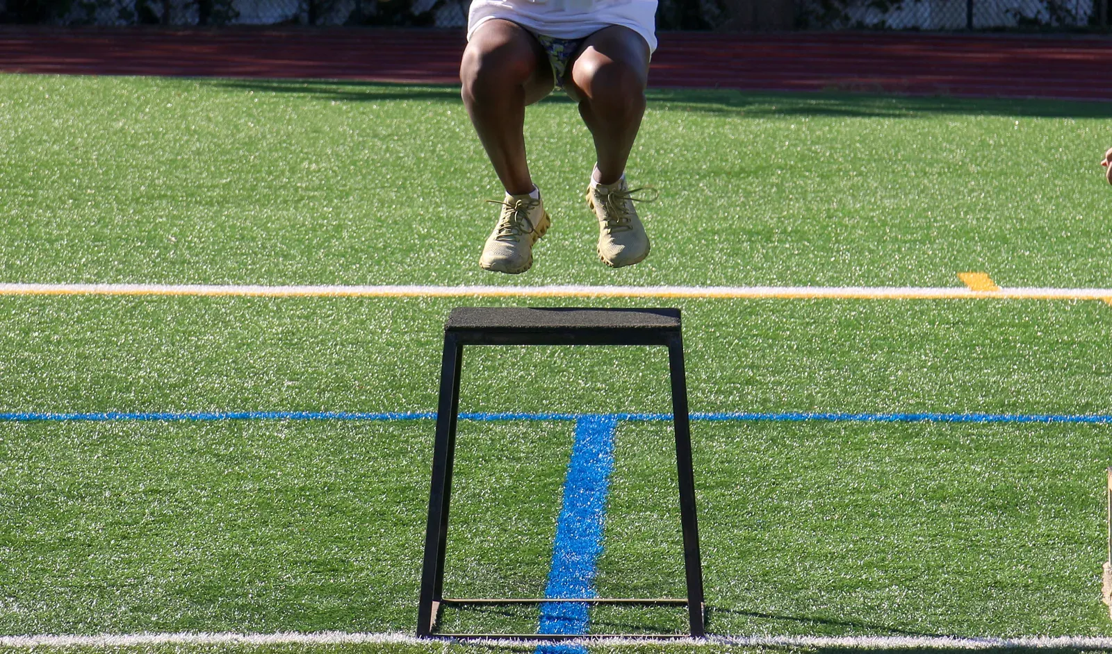 Young athlete performing a vertical jump test while a coach observes