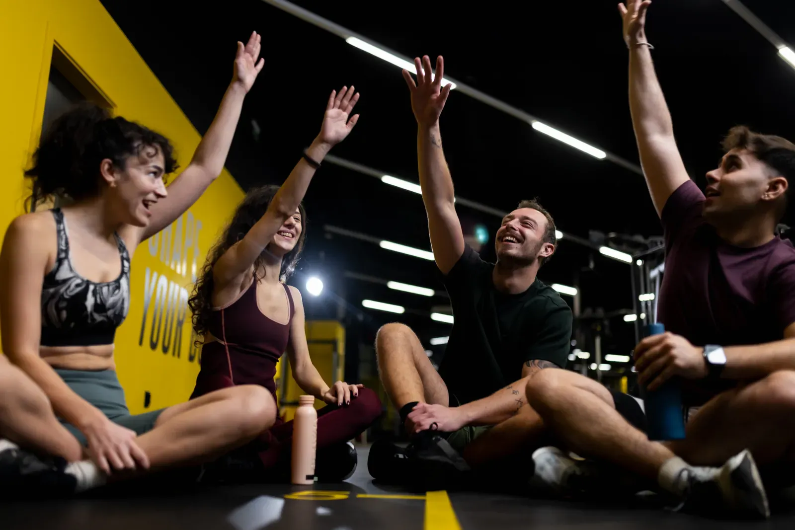 Small group of friends laughing between sets during a workout together