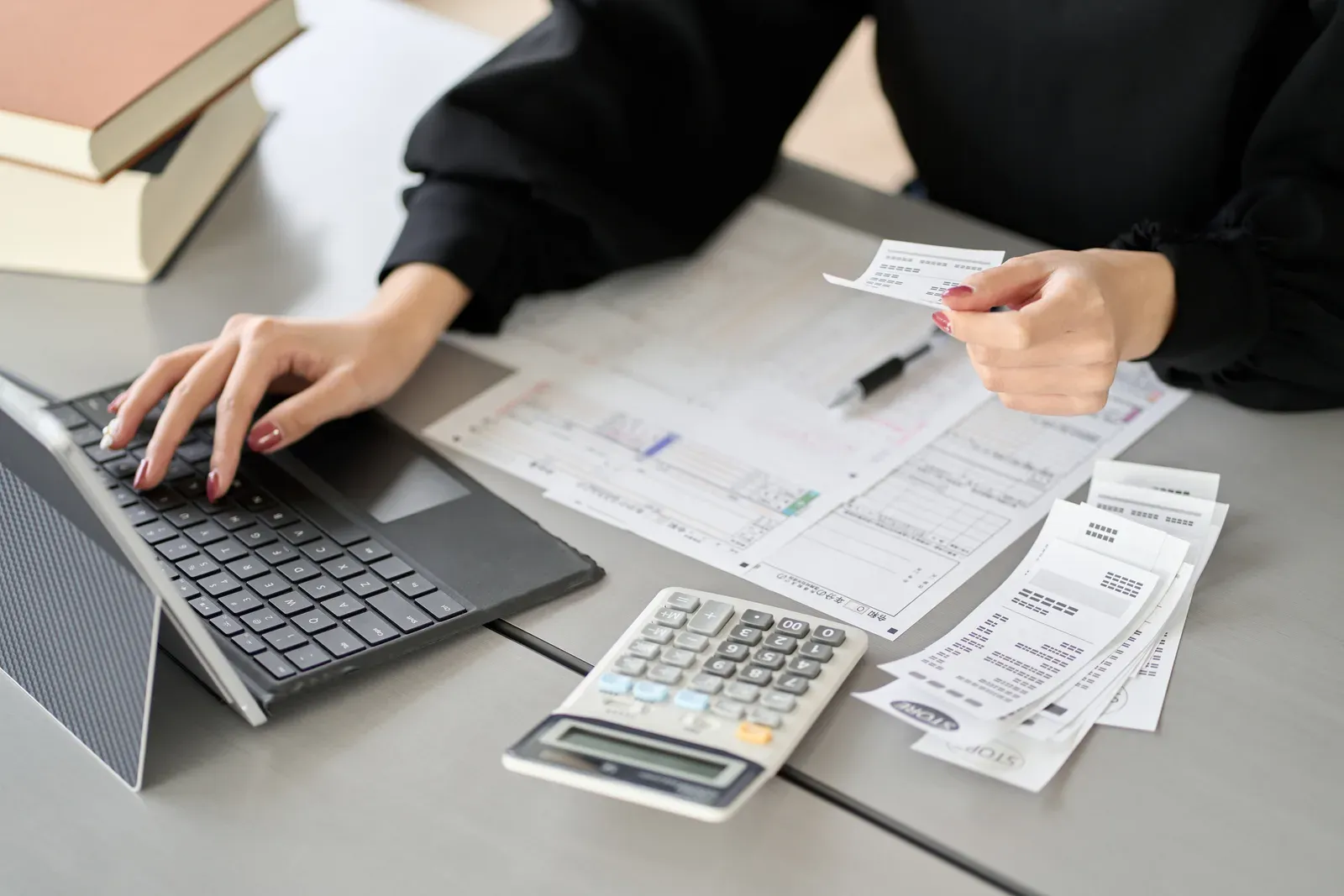 A small business owner reconciling receipts on a laptop