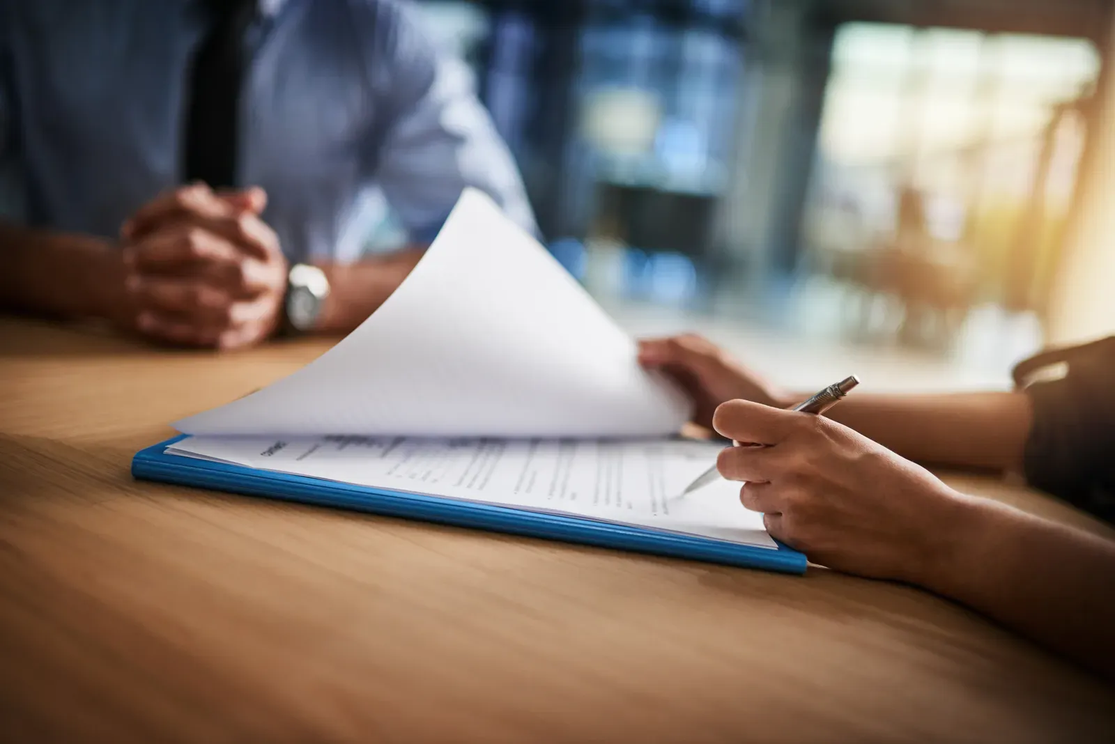 Stack of insurance paperwork with a pen on an office desk