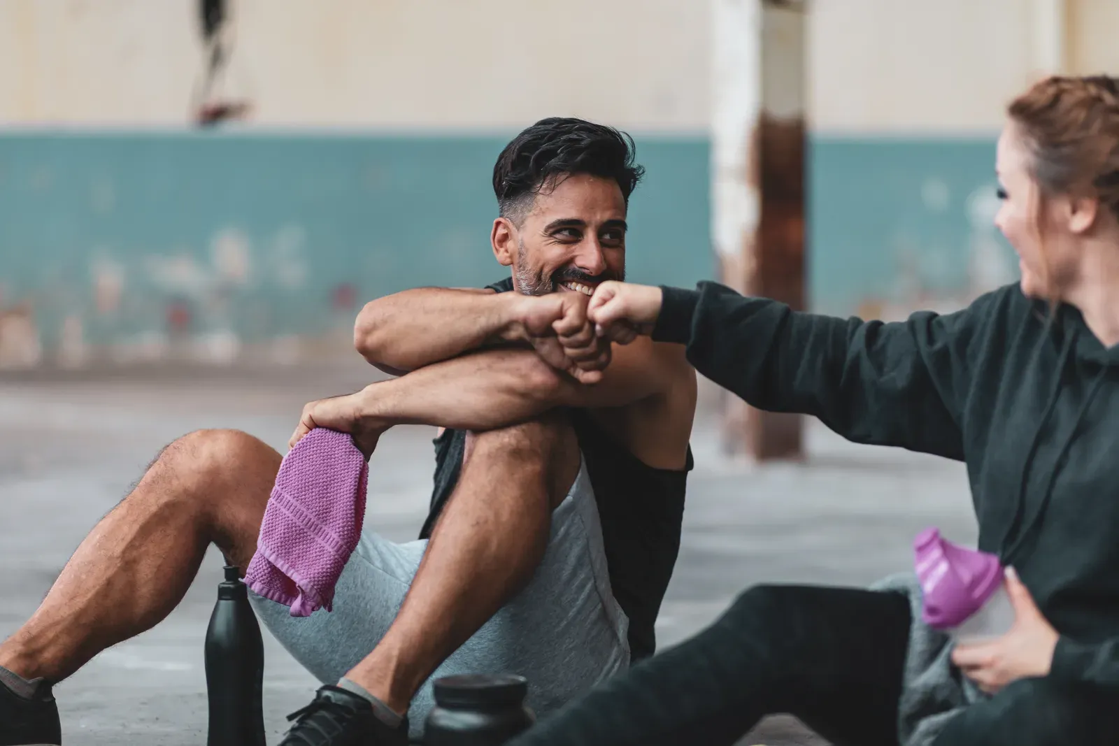 Man and woman in sports clothing sharing a motivating fist bump