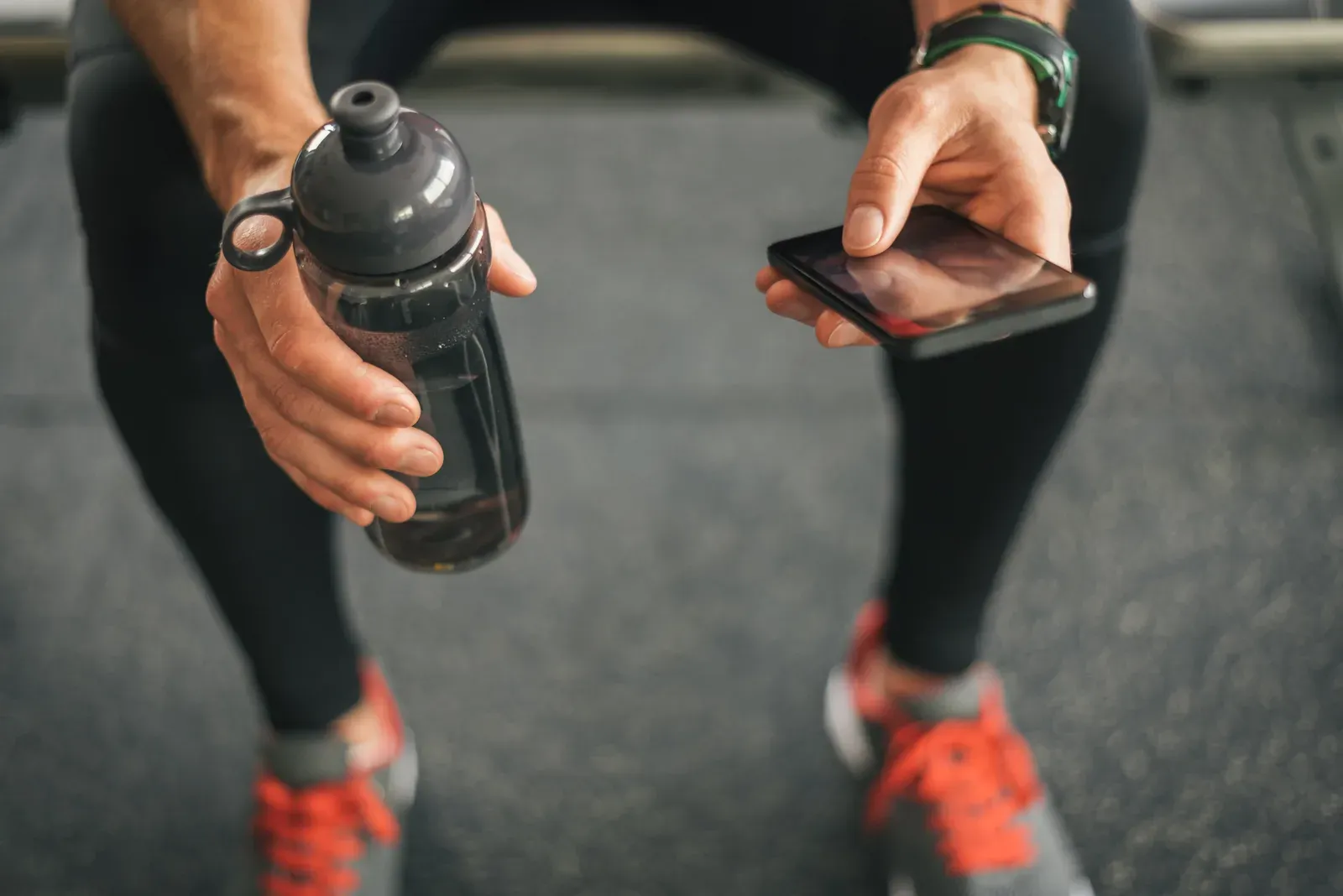 A man checking a fitness app on his phone before his workout
