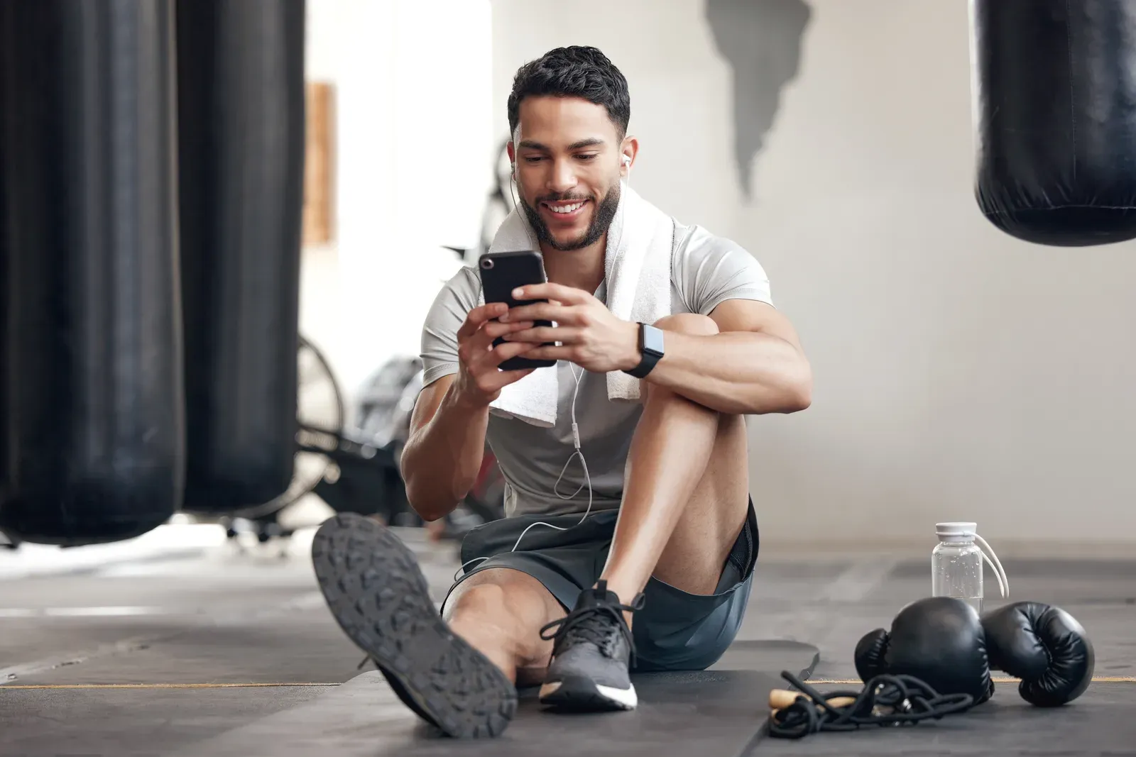 A coach comparing training apps on a phone at a gym desk