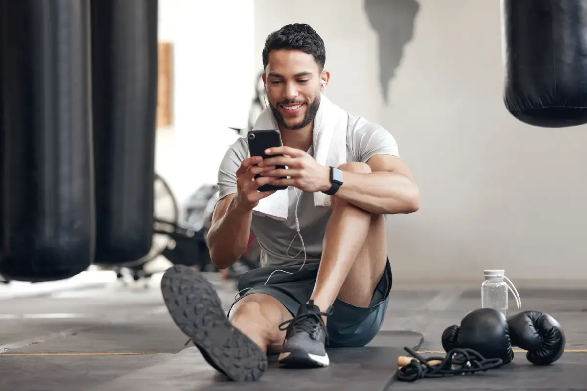 A coach comparing training apps on a phone at a gym desk