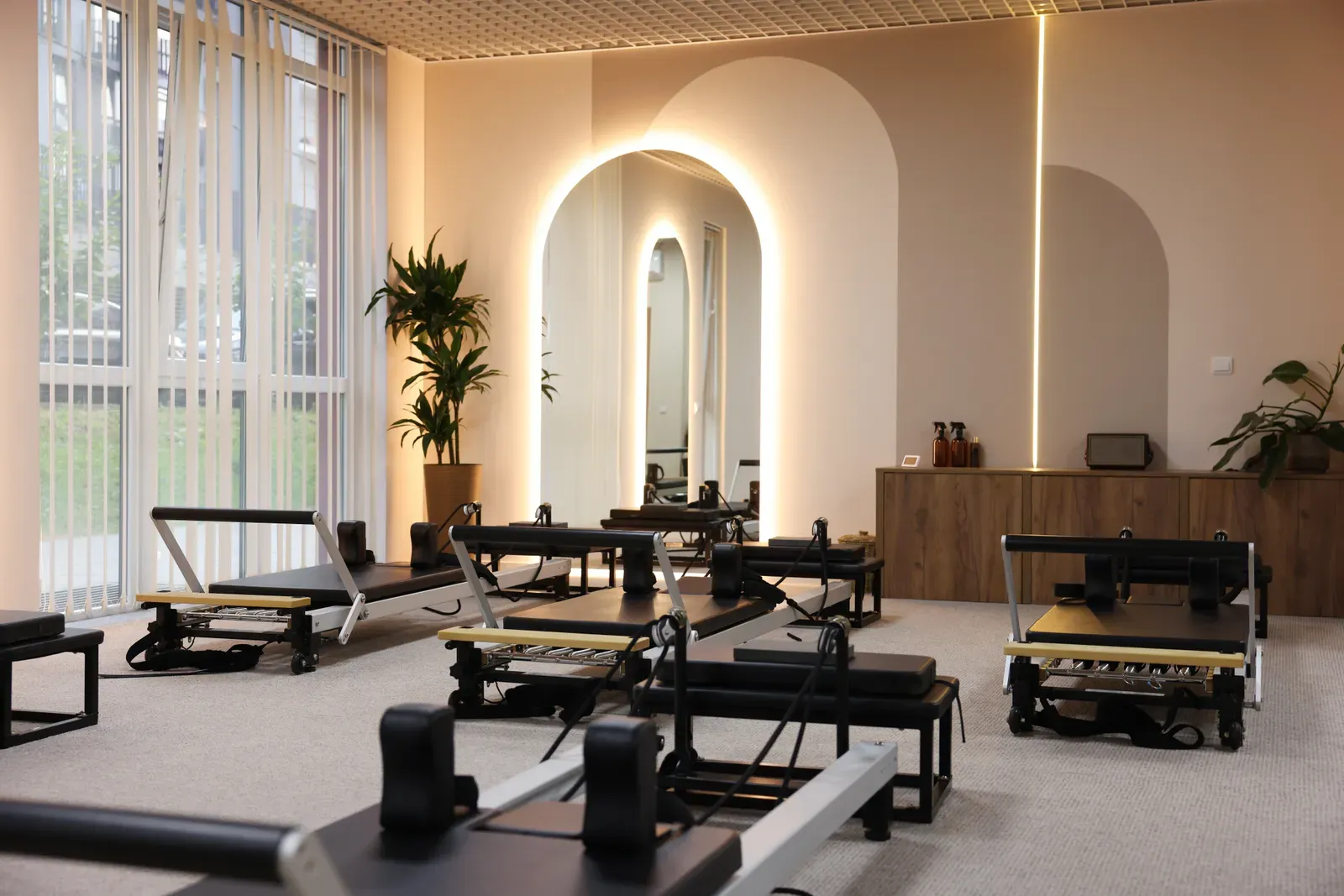Sunlit pilates studio interior with reformers in a row