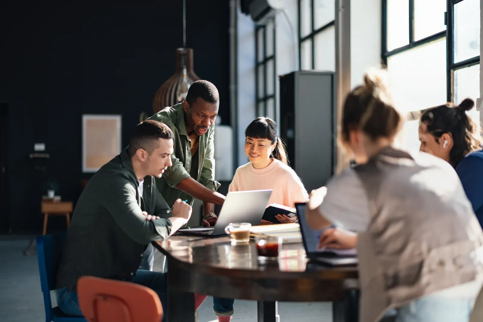 Professionals working at shared desks in a bright coworking space