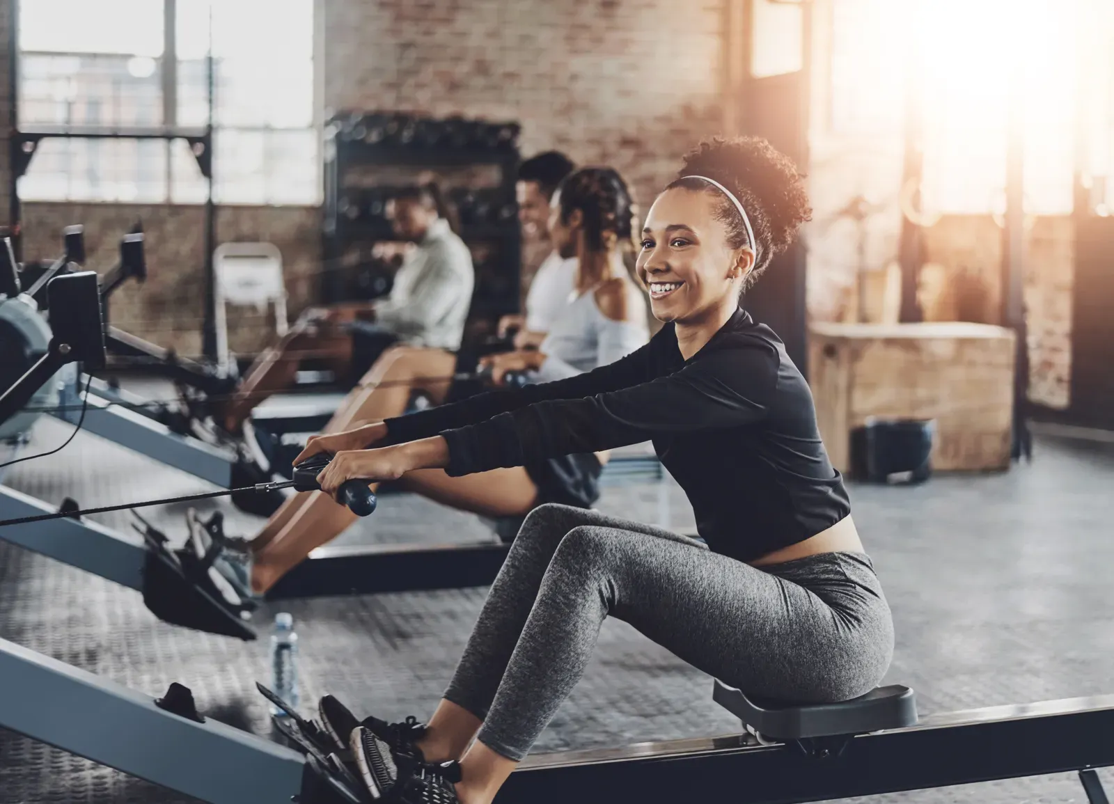 Rowing teammates training side by side on indoor rowing machines
