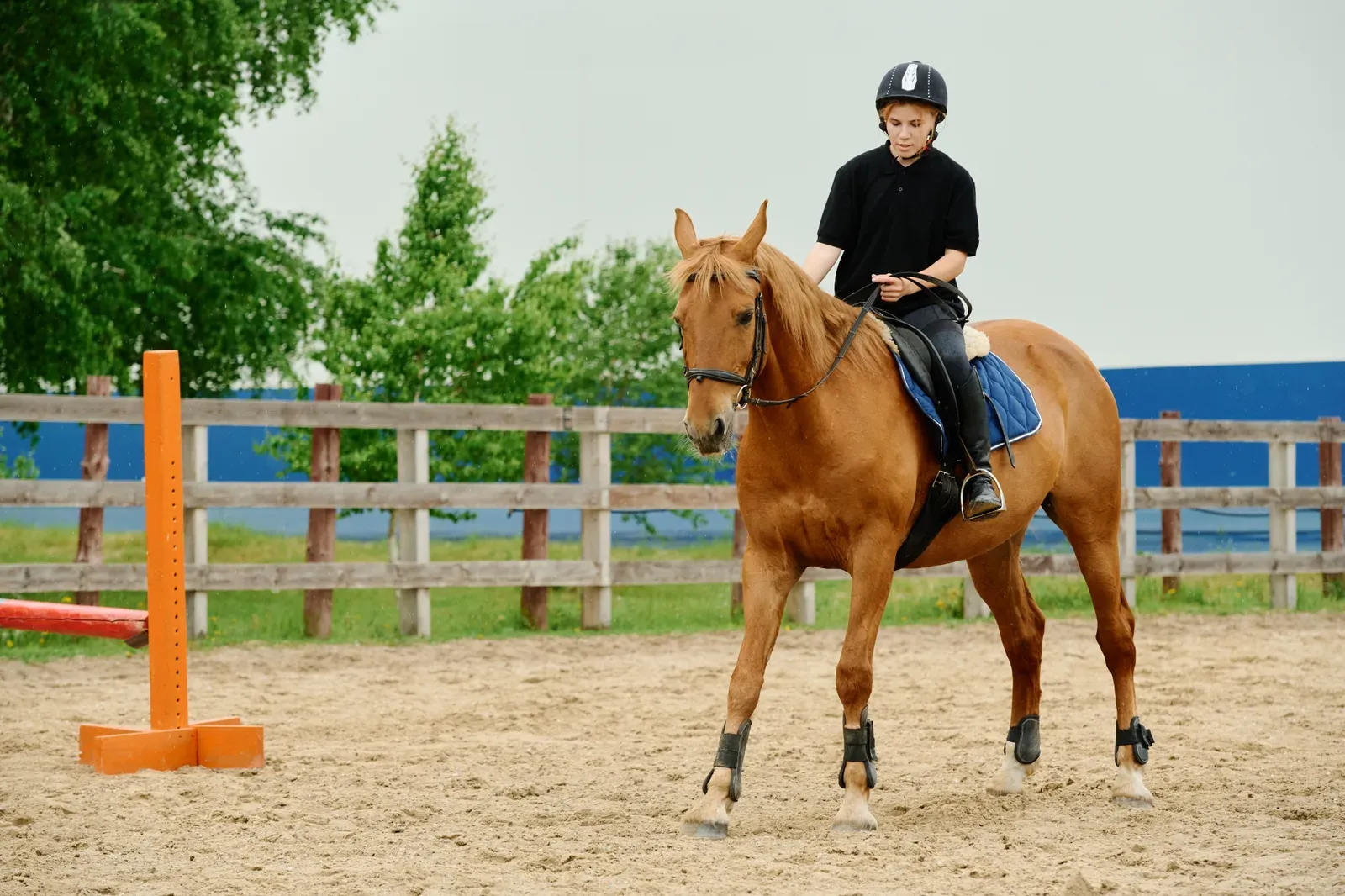 A young rider practicing in an equestrian arena