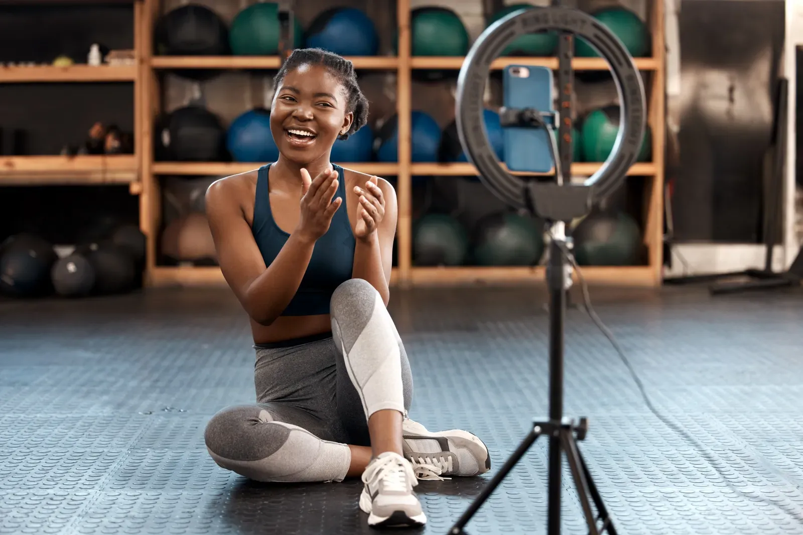 Phone on a tripod recording a workout in an empty gym room