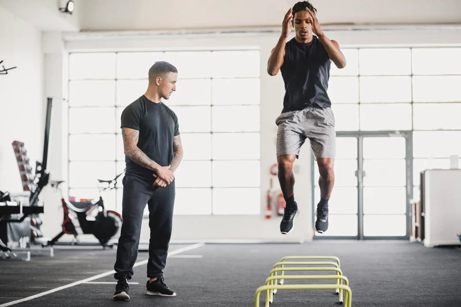 Trainer guiding a client through stretches at the start of a session