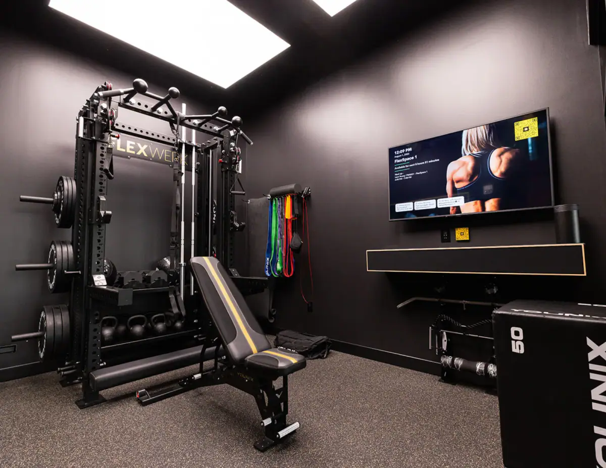 Fully equipped private gym room in Carmel with a rack, bench, and dumbbells