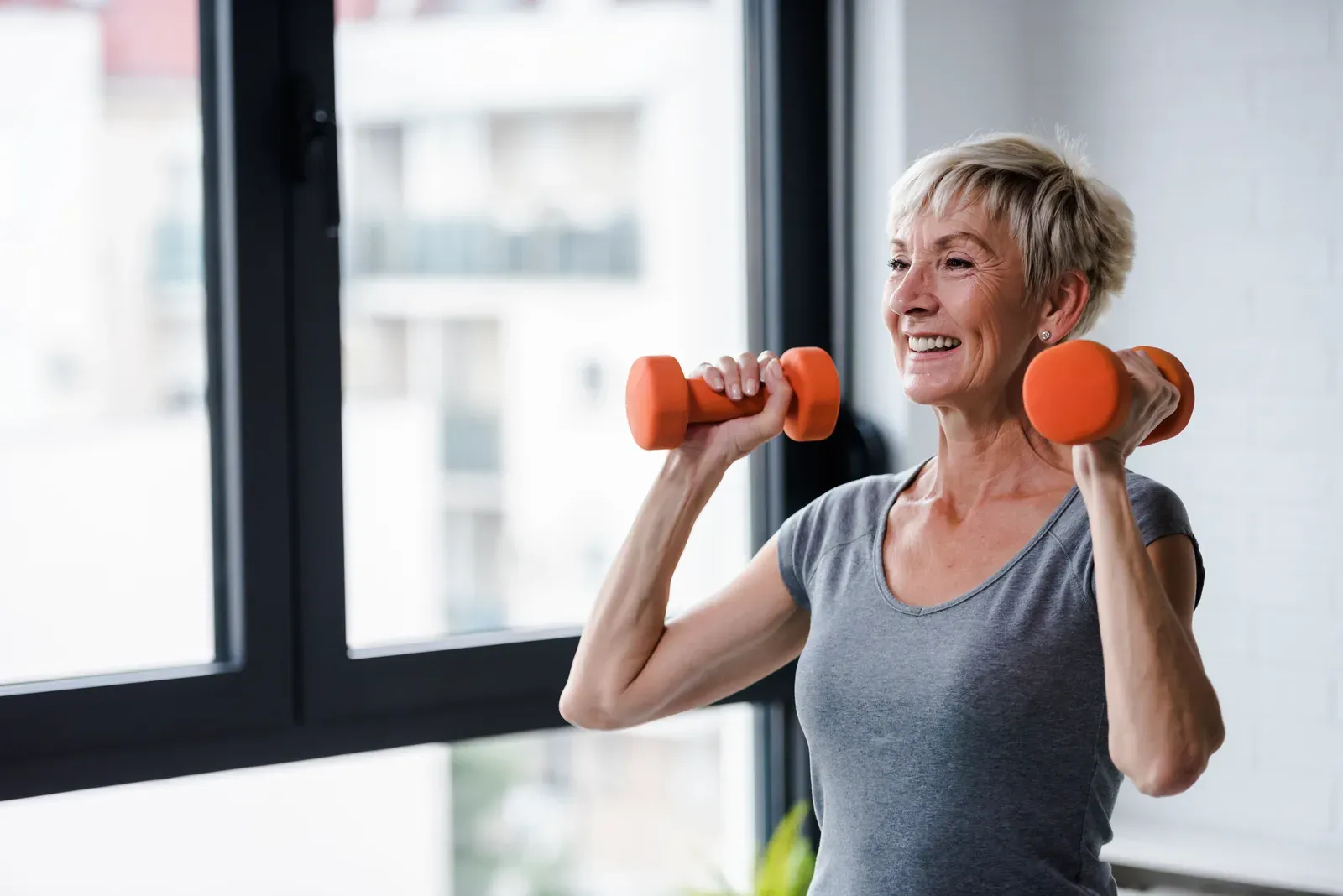 Senior woman lifting dumbbells, the strength work that protects muscle on GLP-1