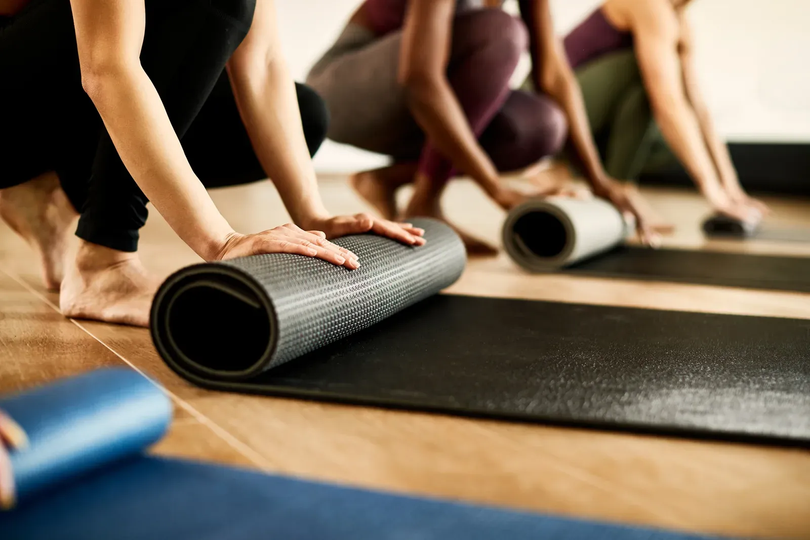 Athletic woman rolling up her exercise mat after class at a health club