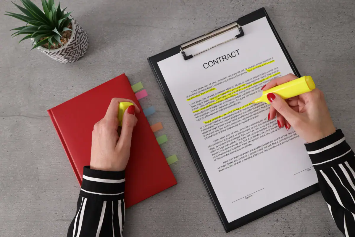 Businesswoman underlining terms of a contract with a yellow highlighter, a close read of a gym independent contractor agreement