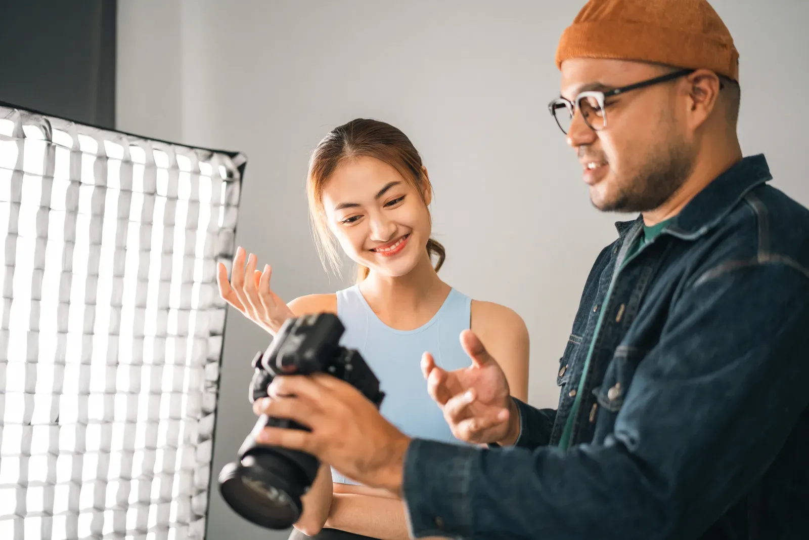 Photographer shooting a fitness model beside a lifting rack with studio lighting