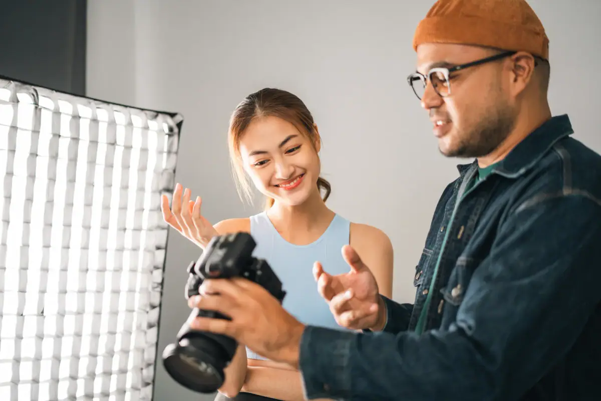 Photographer shooting a fitness model beside a lifting rack with studio lighting