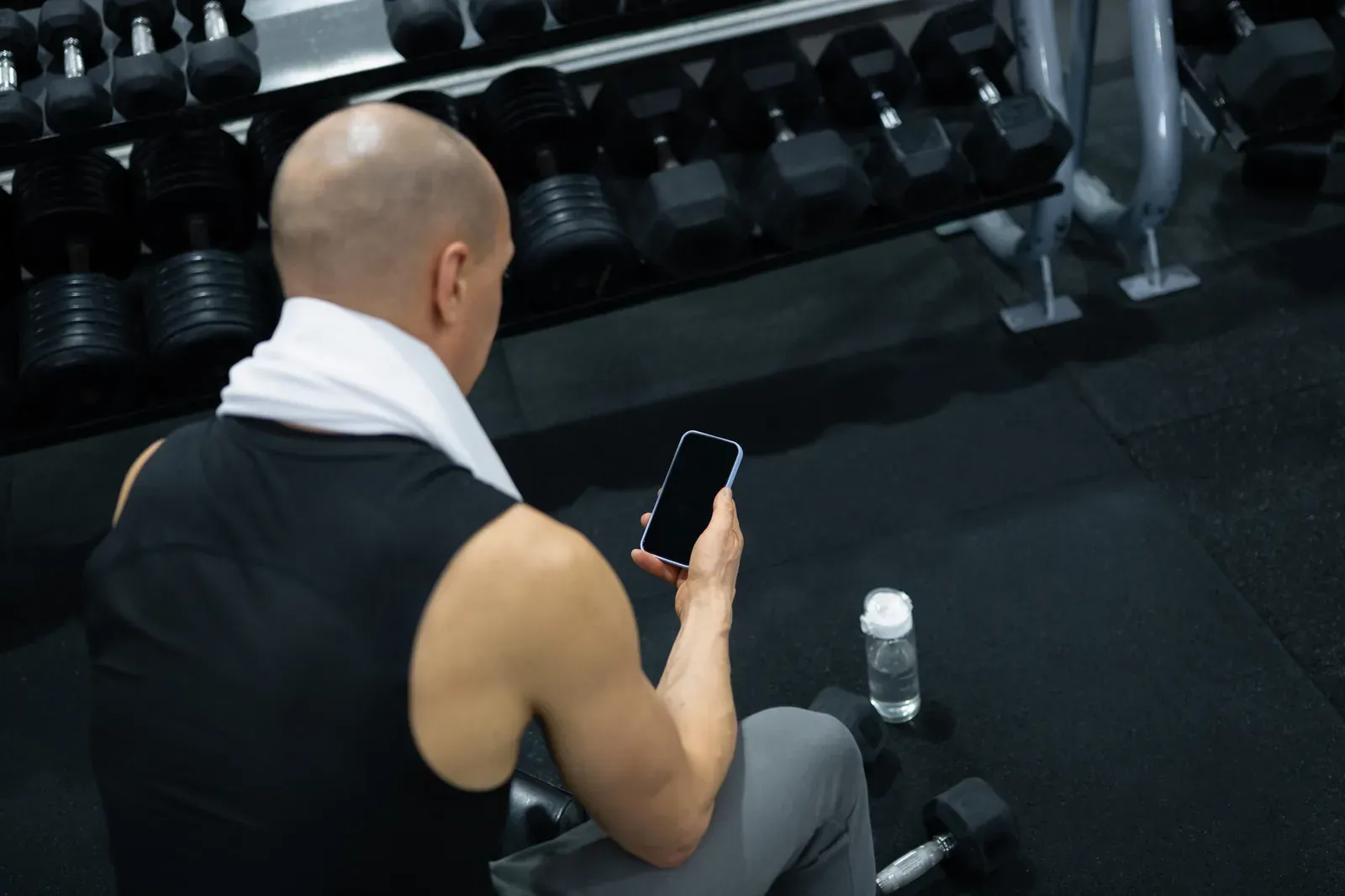 Person reviewing notes inside an empty fitness space