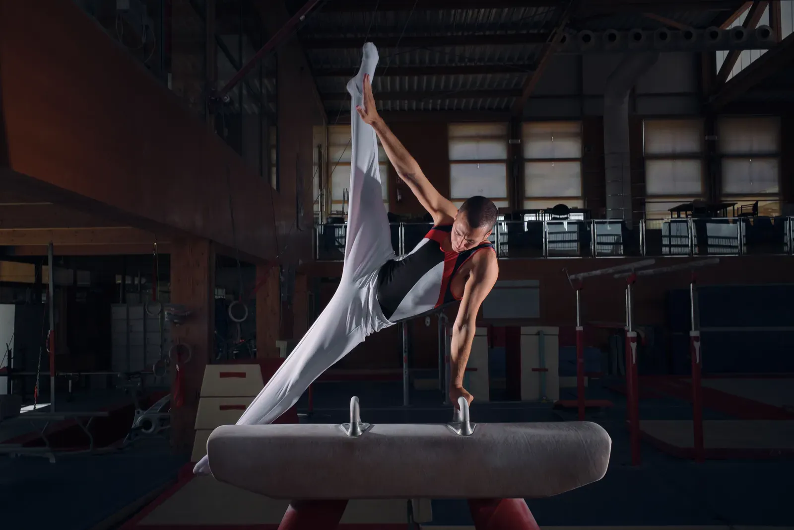 Young gymnast building strength with dumbbells under a coach's supervision