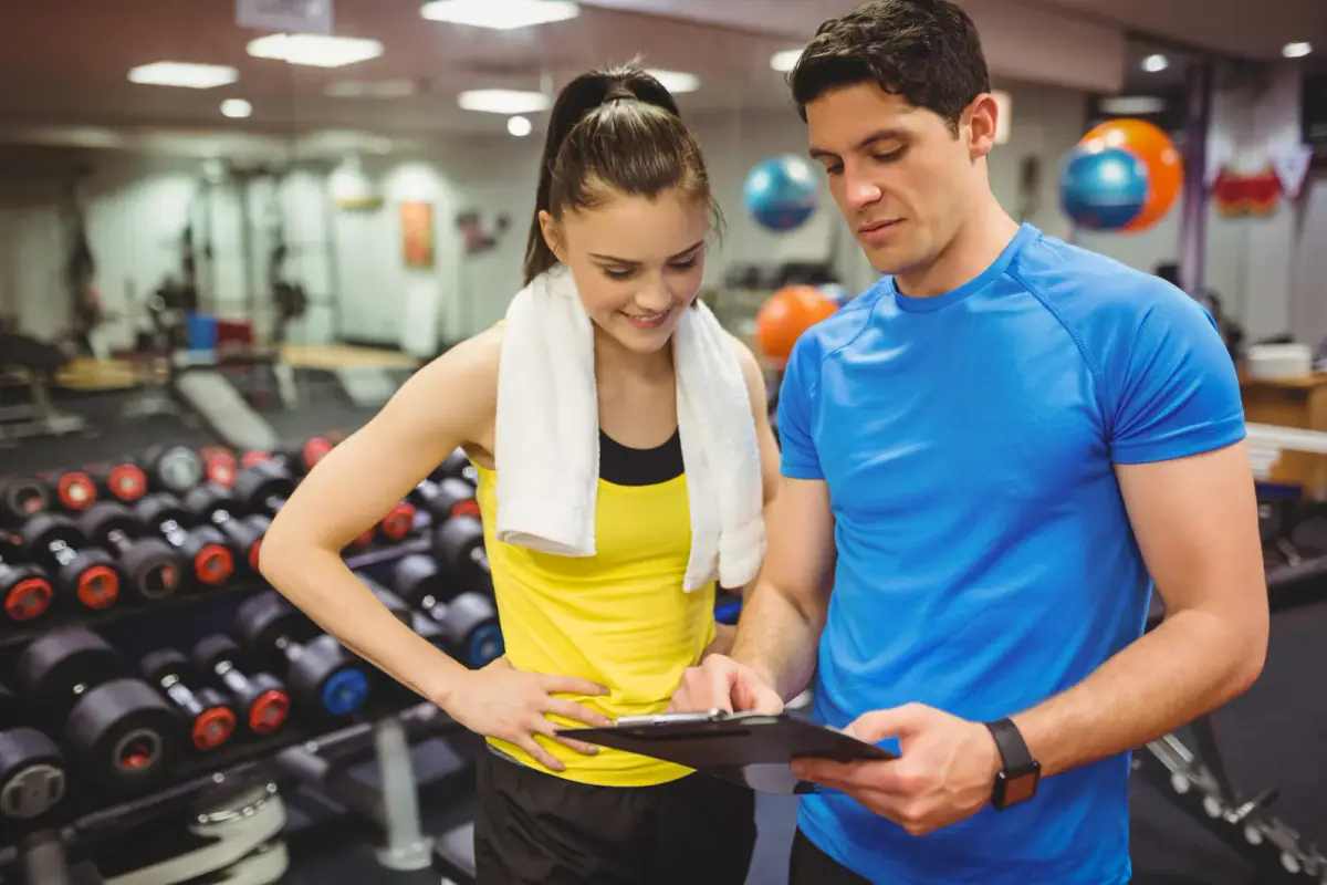 A trainer and client discussing her progress, relevant to deciding how much to discount session packages