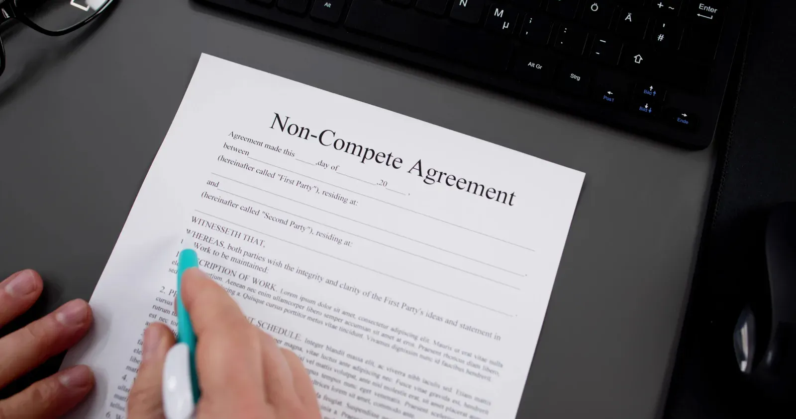 A non-compete agreement document on a desk beside a pen