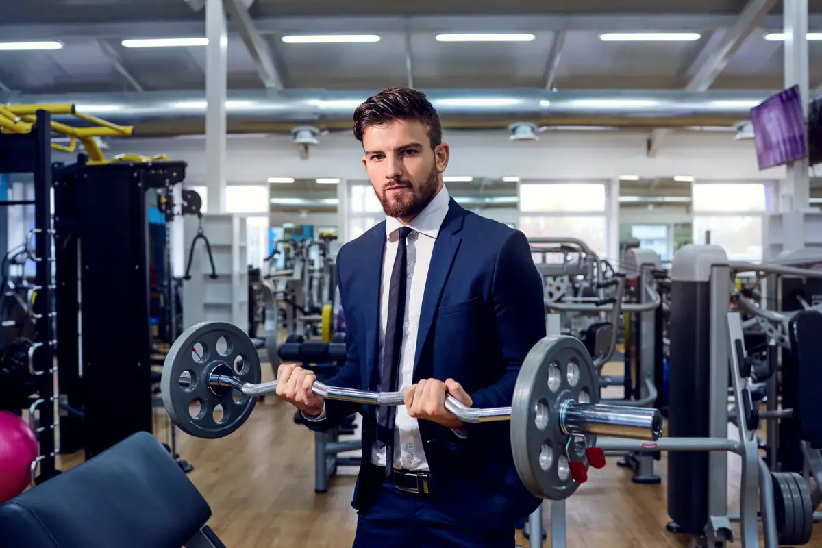 A professional in a suit fitting in a barbell workout