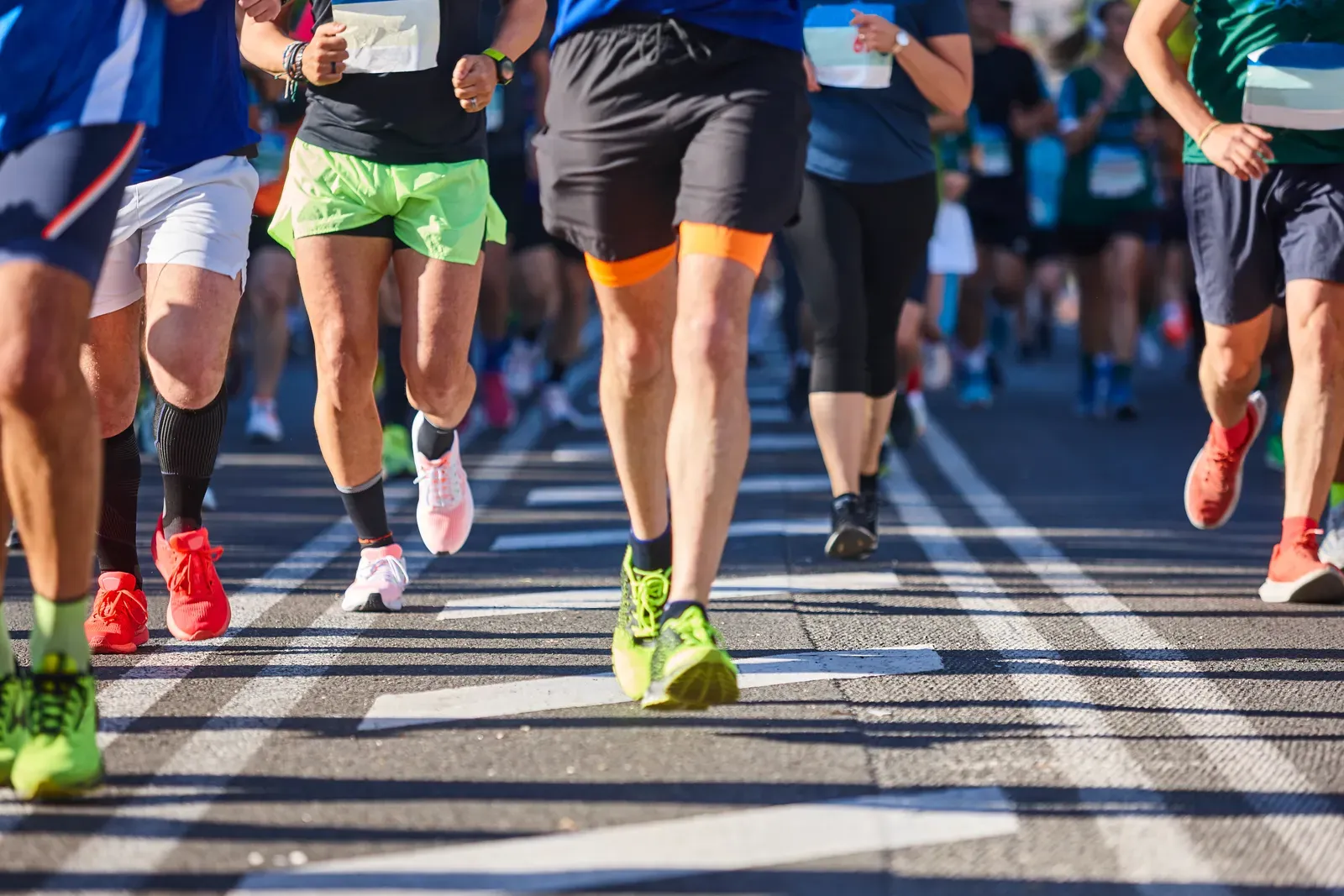 Distance runners crossing a striped city street during a road race