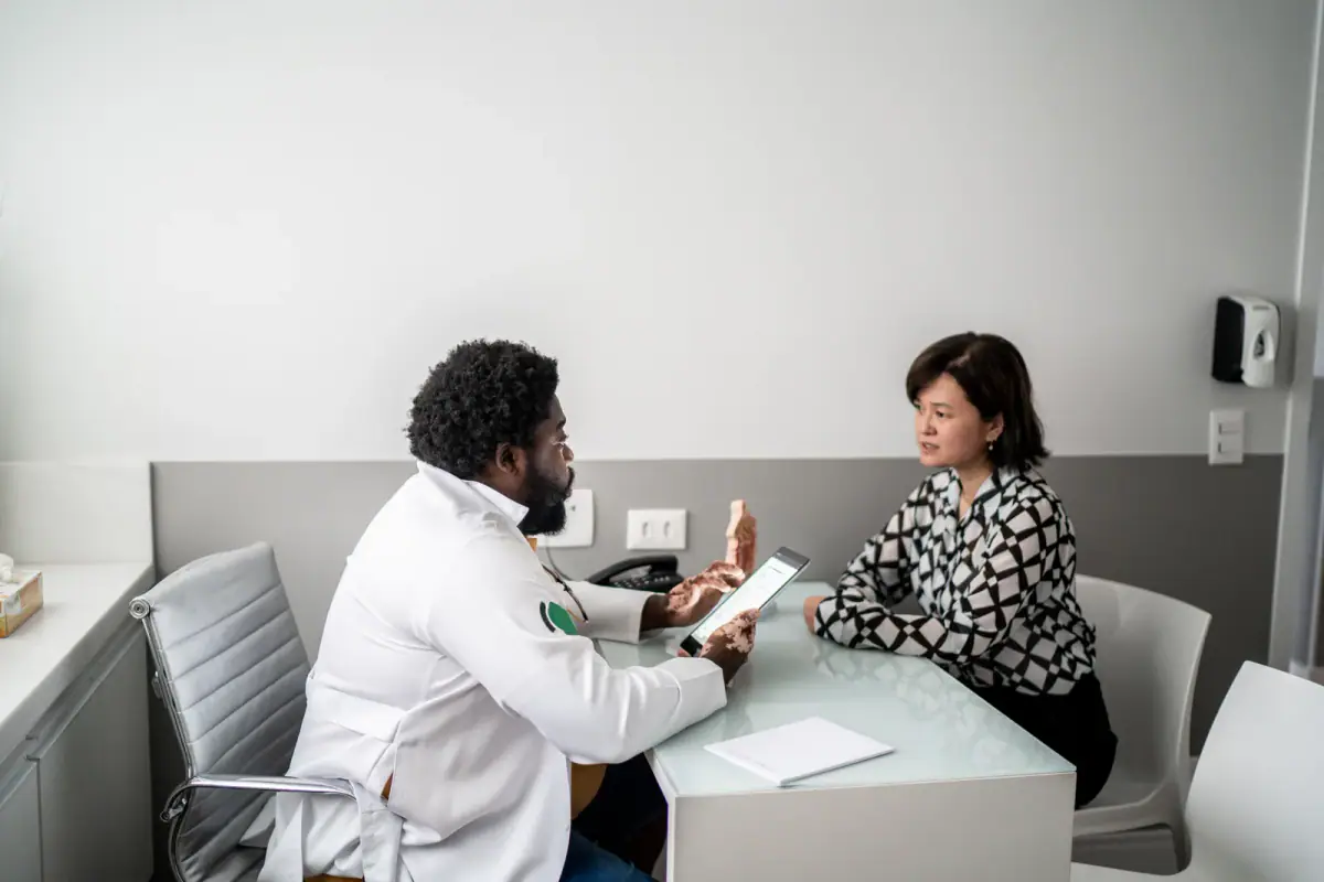 A physician talking with a patient in a bright clinic office