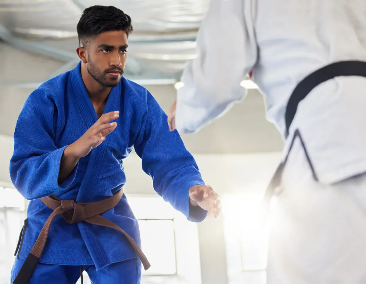 Student learning self defense from a taekwondo expert in a dojo, a private lesson that martial arts instructor insurance should cover