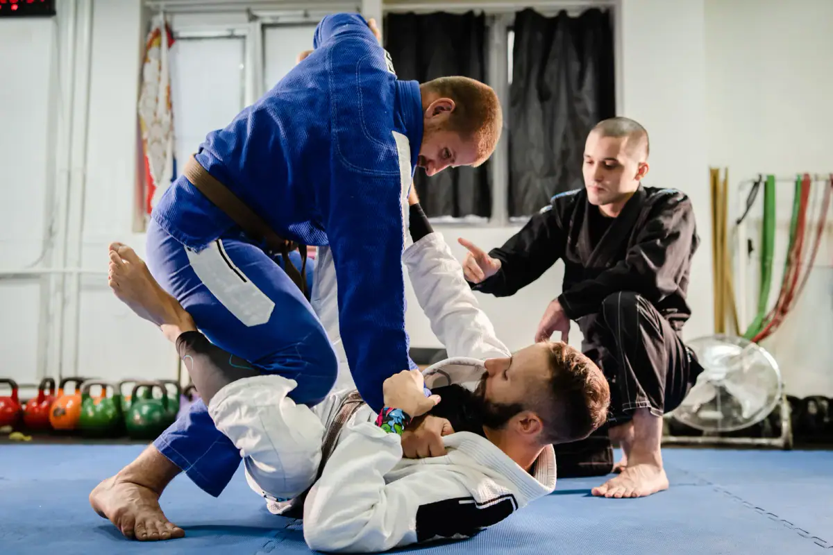 Brazilian jiu jitsu professor working on technique details in a private class, the student bond at stake when leaving a school