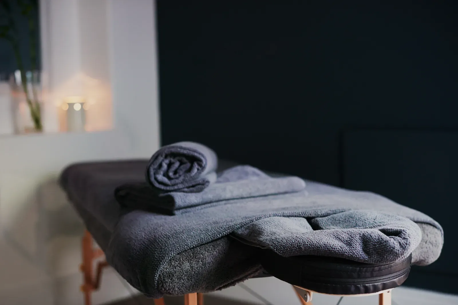 Massage table set up in a quiet room with folded linens