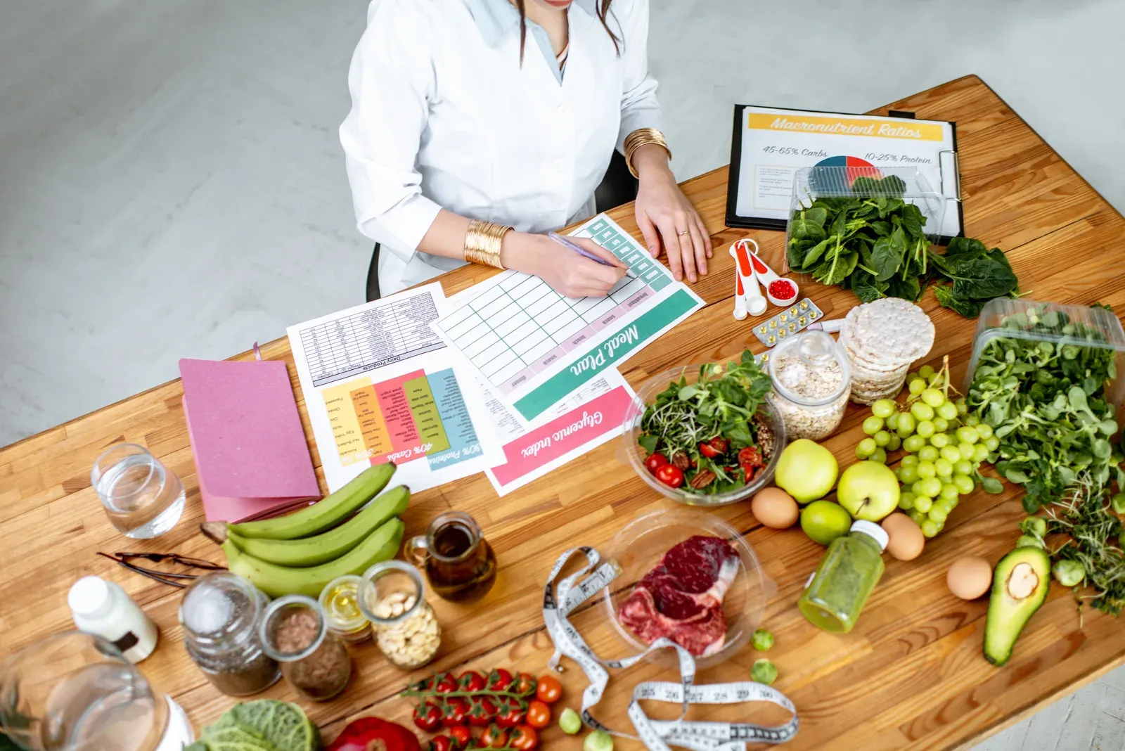 Writing a diet plan at a table filled with healthy food