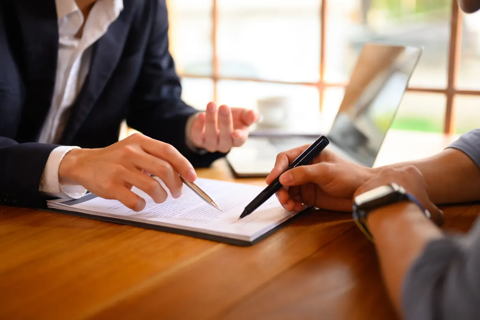 Signing an insurance document at a desk with a pen