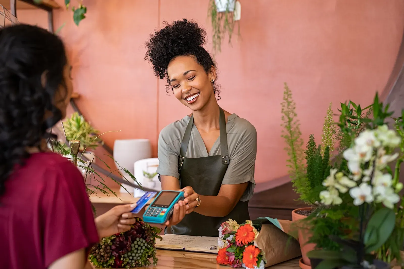 A customer tapping a credit card on a mobile card reader