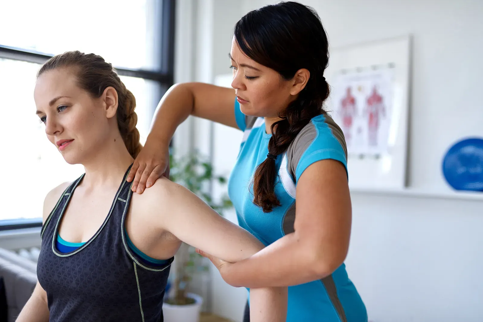 Physical therapist talking a patient through an exercise in a bright private room