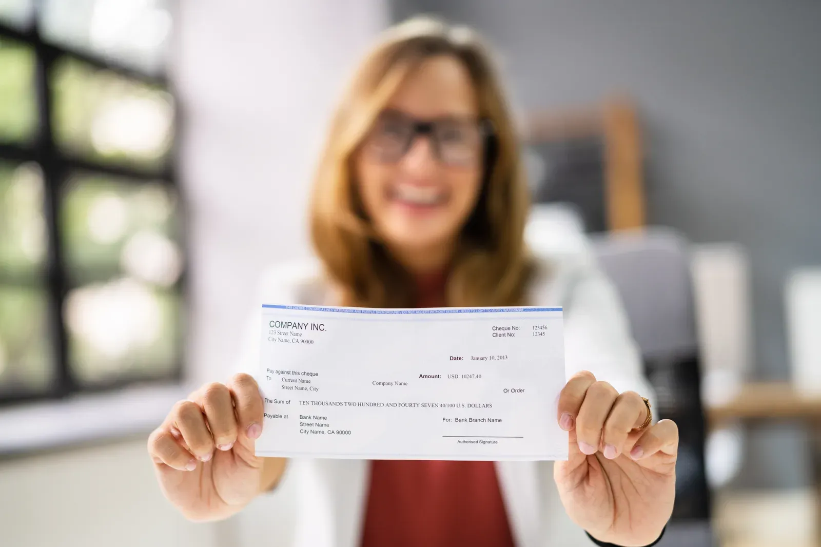 Hands holding a paycheck ready to deposit