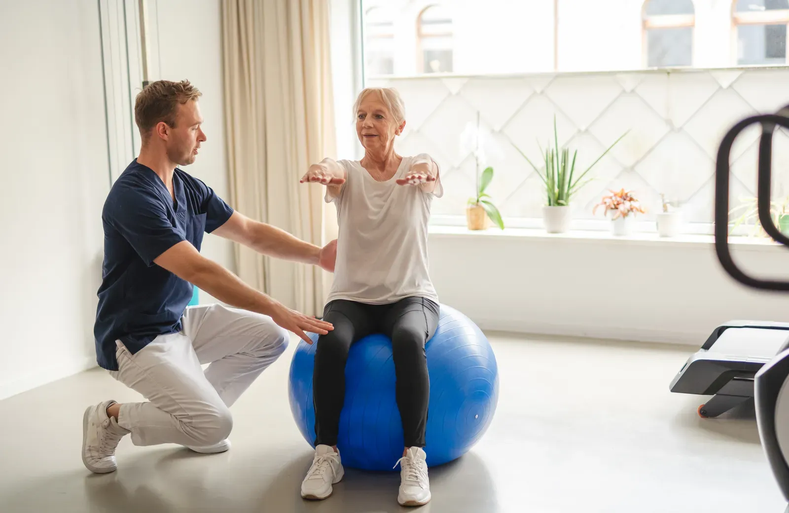 Physical therapist guiding a patient through a resistance exercise
