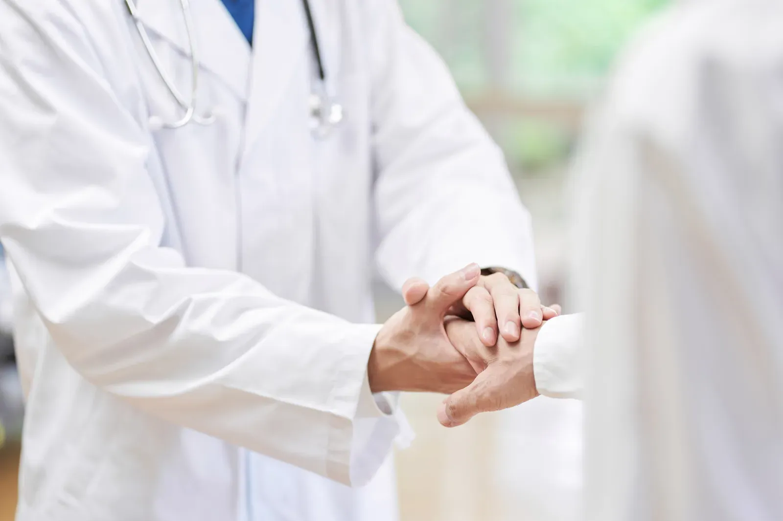 Physician shaking hands with a visiting professional in a medical office