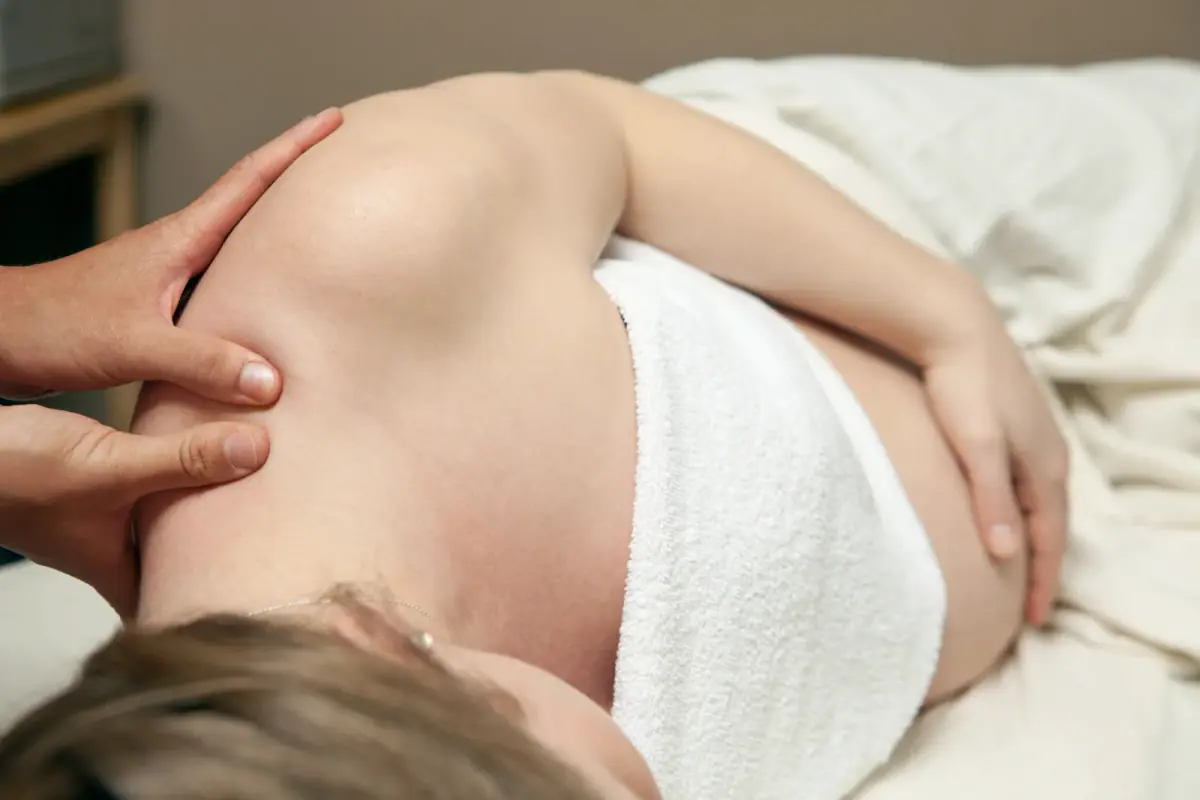 Pregnant woman receiving a prenatal massage, a service that needs a private room for a prenatal massage therapist