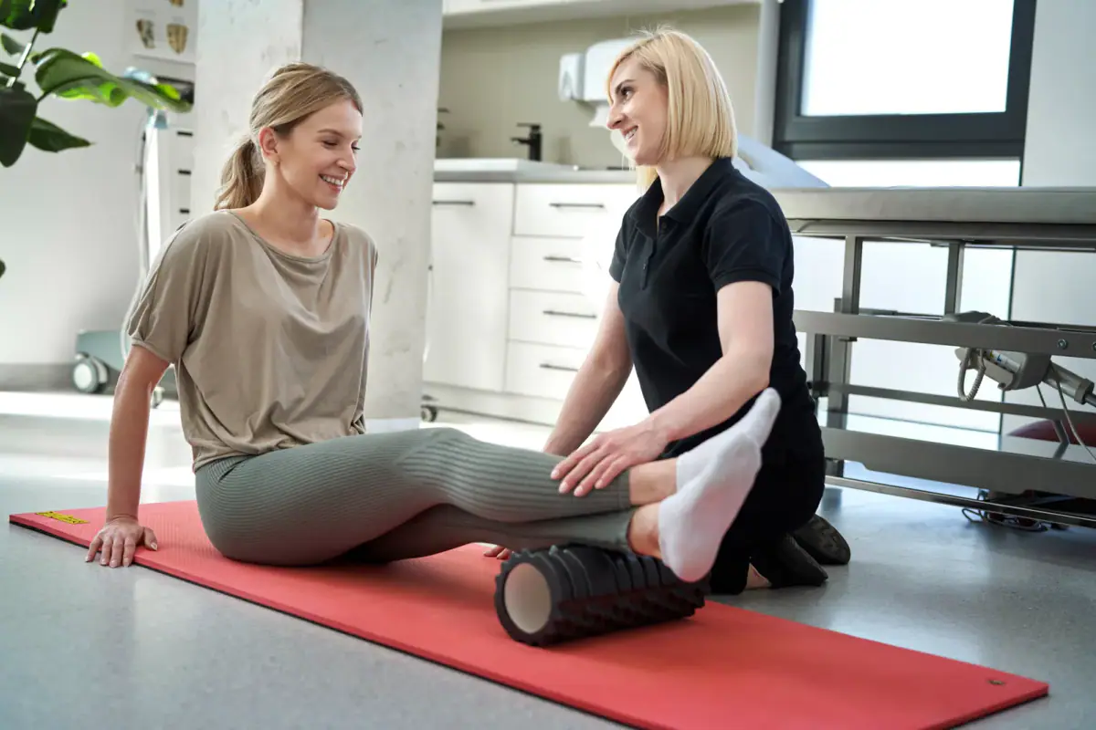 Athlete working through foam roller recovery drills on a training room floor
