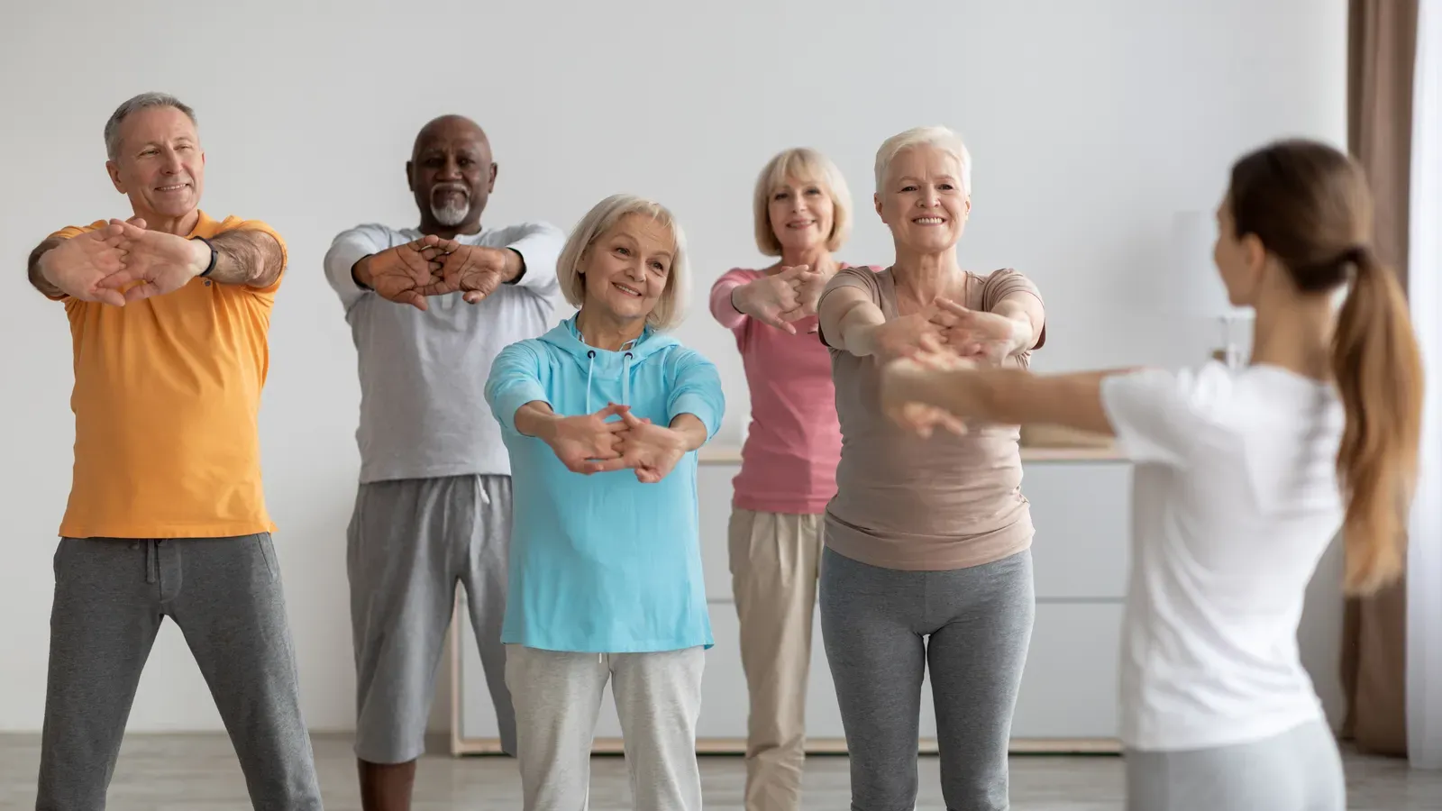Small group stretching together in a bright community fitness session