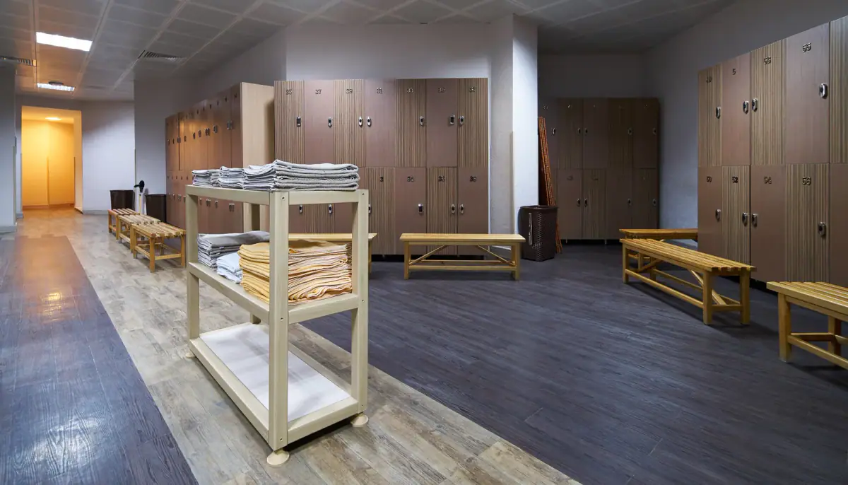 A tidy changing area with wooden benches and a clean shelf, relevant to restrooms and changing space for clients