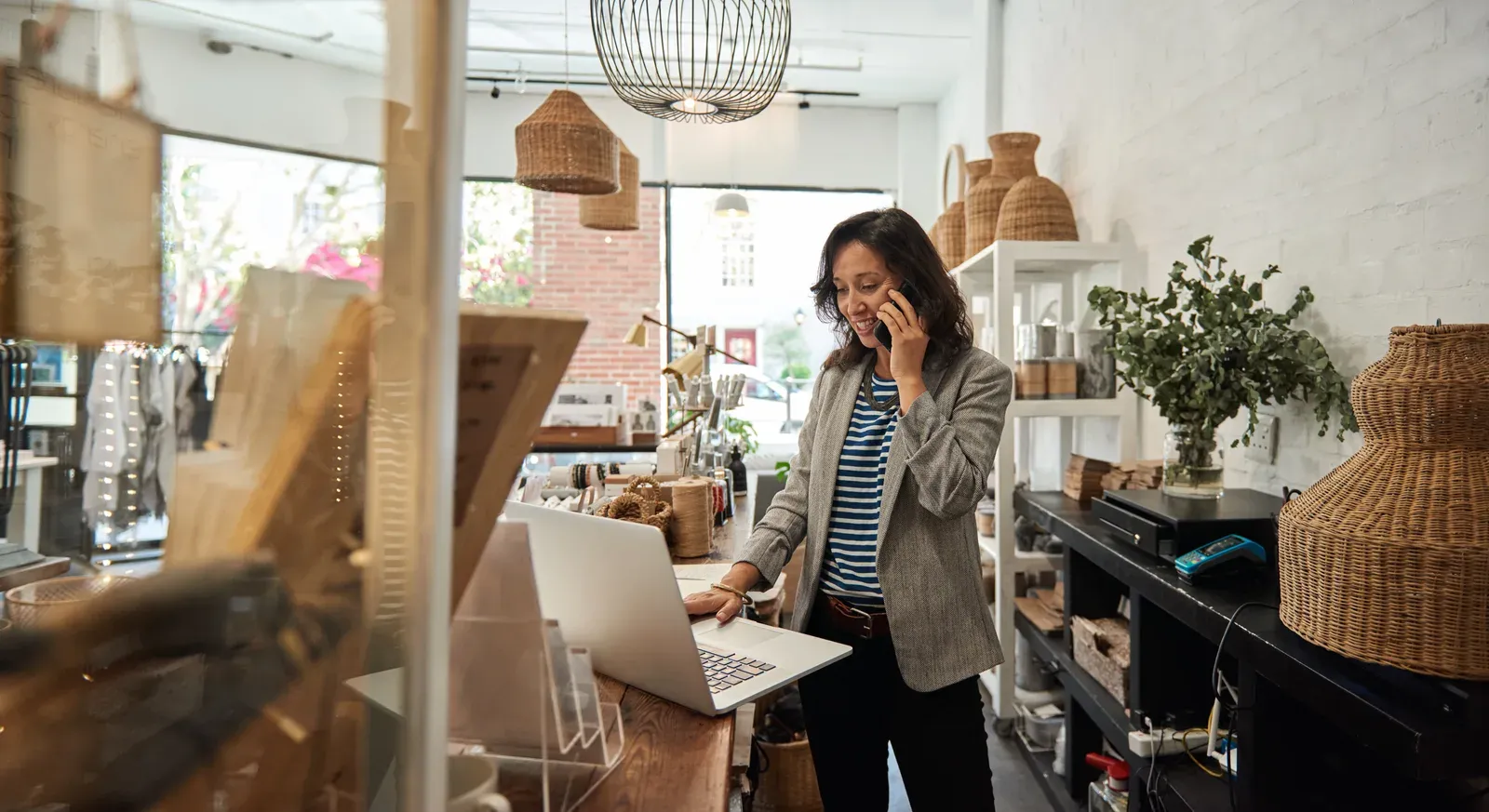 Smiling shop owner taking a phone call inside her own store