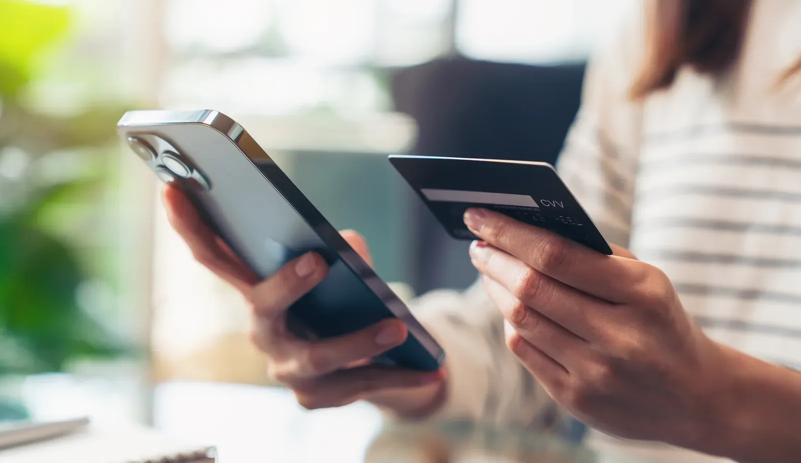 Holding credit cards while paying by phone, the app-based way many clients pay