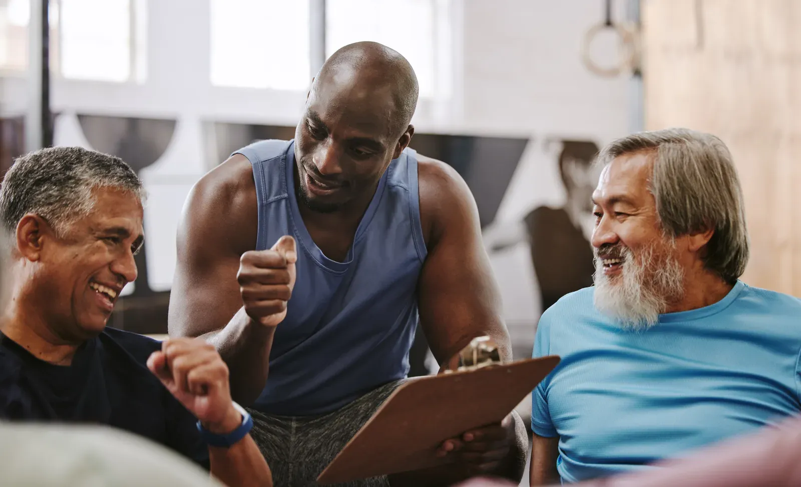 Coach going over a training checklist with older adults at the gym