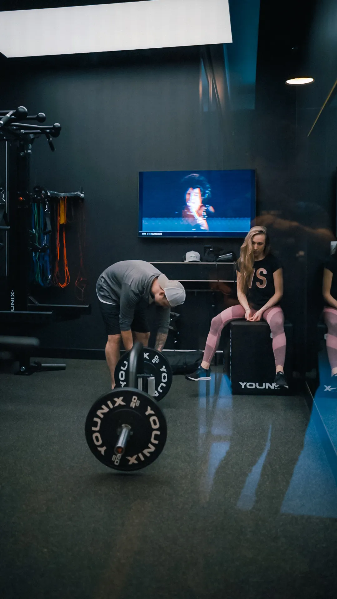 A coach guiding a client through a cable exercise inside a FlexSpace Plus space