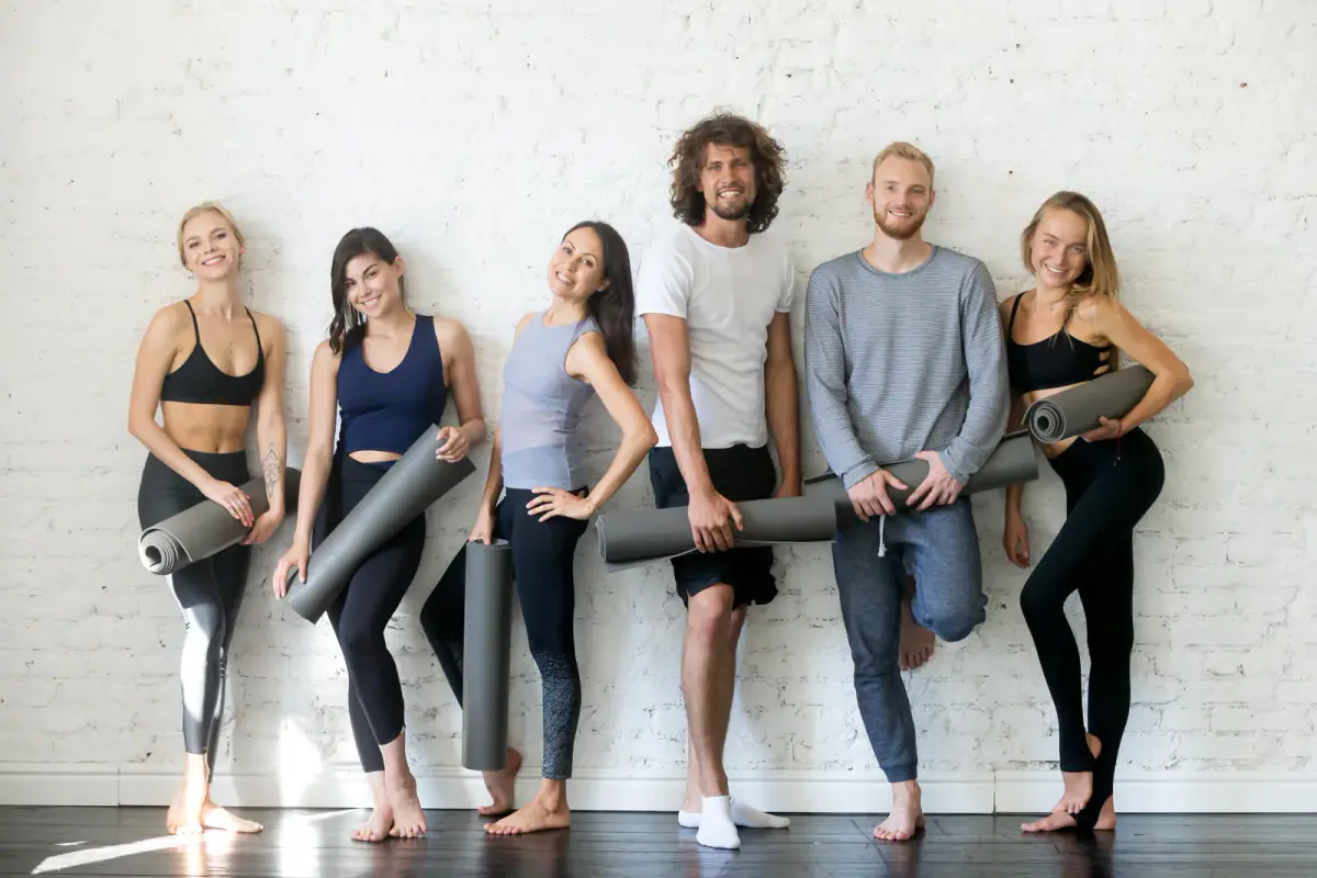 A group portrait of happy young fitness instructors, relevant to a shared studio co-op