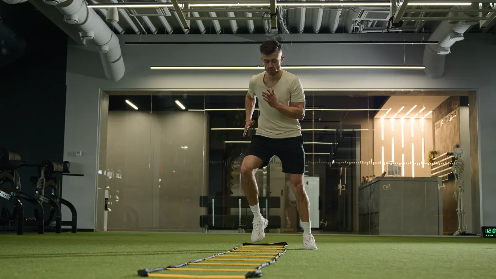 Soccer player building leg strength with a coach in a training room