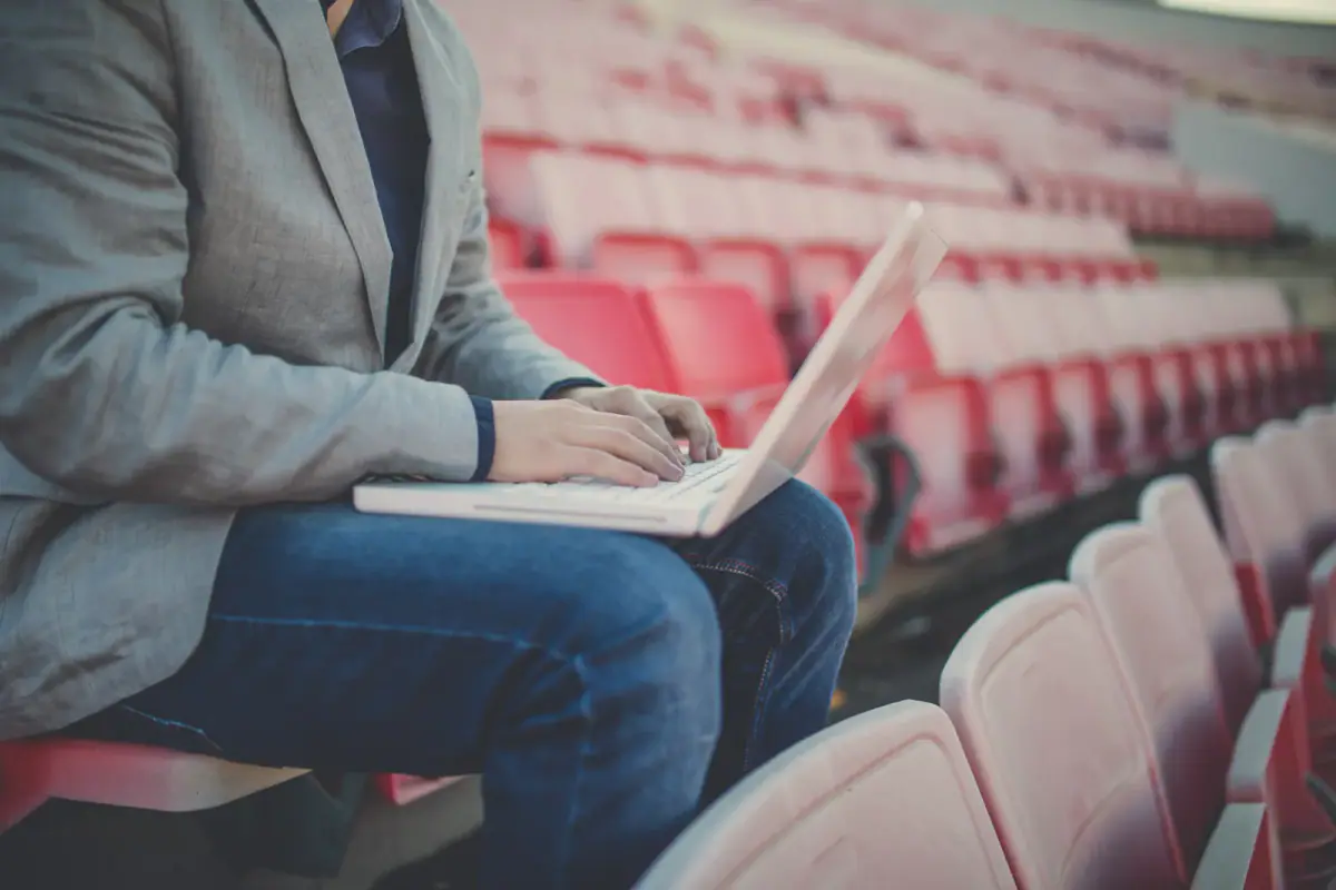 A coach working on a laptop between training sessions