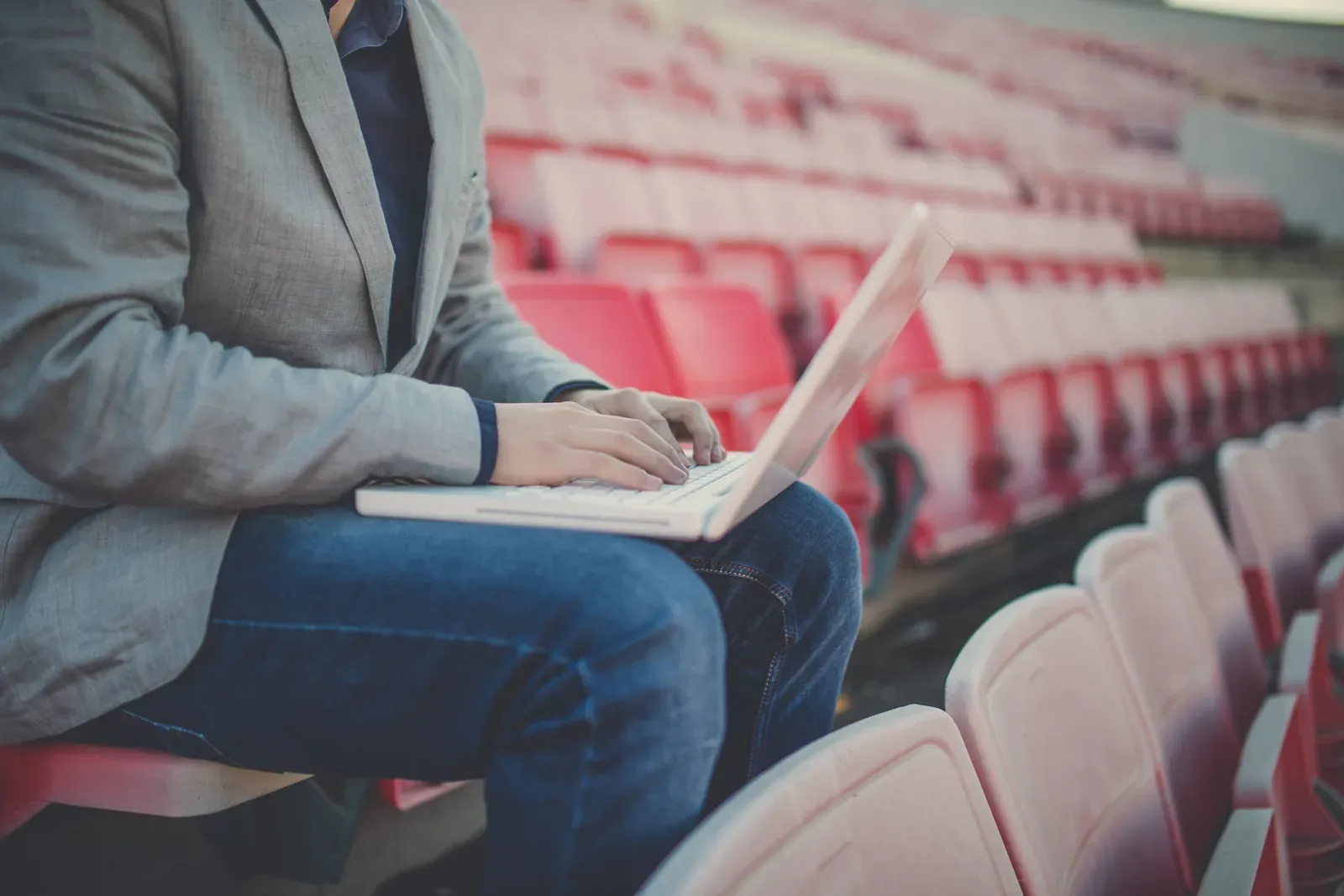 A coach working on a laptop between training sessions