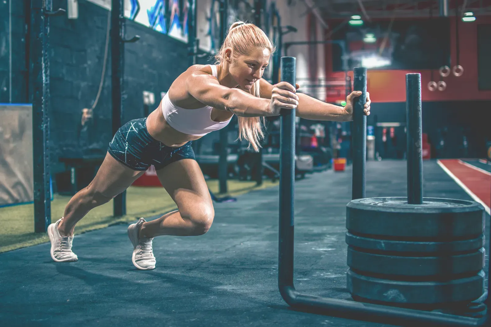Athlete driving a weighted sled during a conditioning session